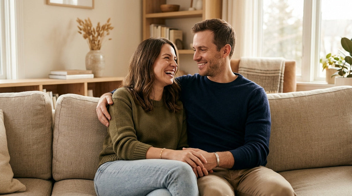 Couple souriant sur un canapé, chacun portant un bracelet visible au poignet Image