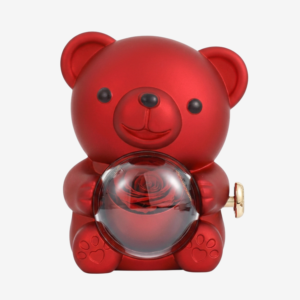 Vue en angle de l'ourson rouge montrant la rose rouge stabilisée à l'intérieur de la sphère en verre