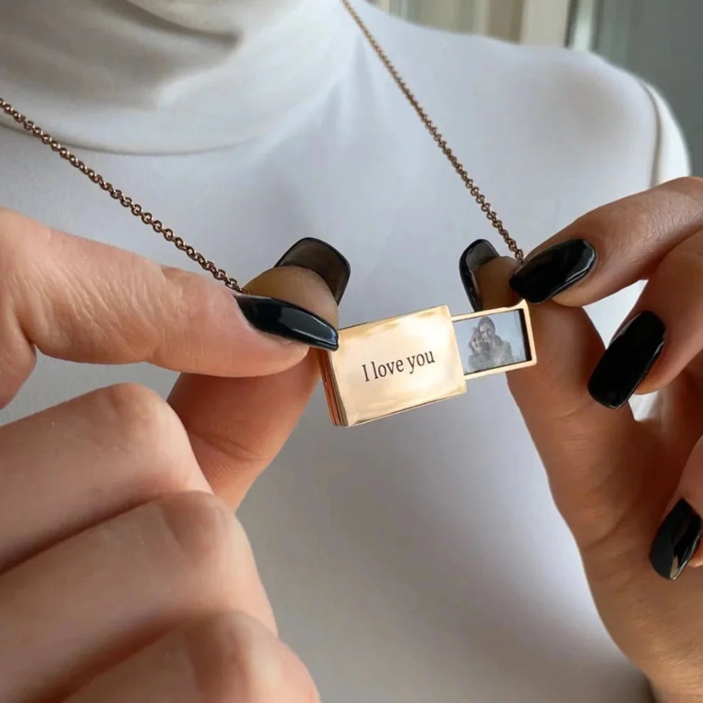 Collier avec photo personnalisé en or tenu dans les mains, photo imprimée visible