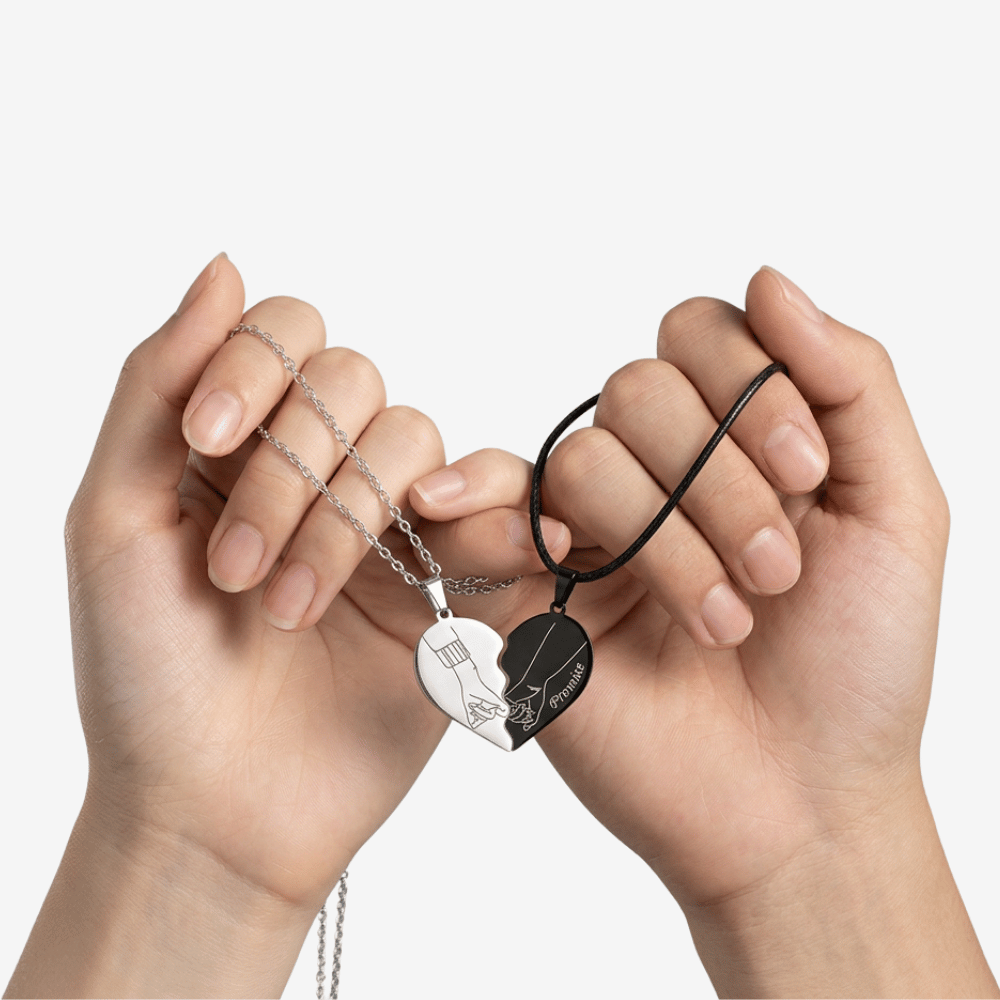 Collier pour couple amoureux tenu par deux mains, moitiés de cœur assemblées