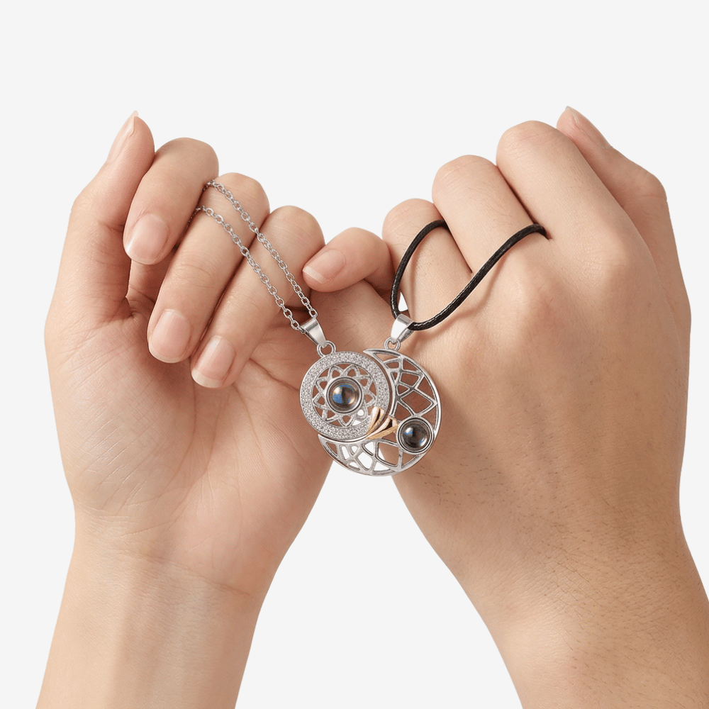 Collier pour couple soleil et lune tenu par deux mains, médaillons assemblés