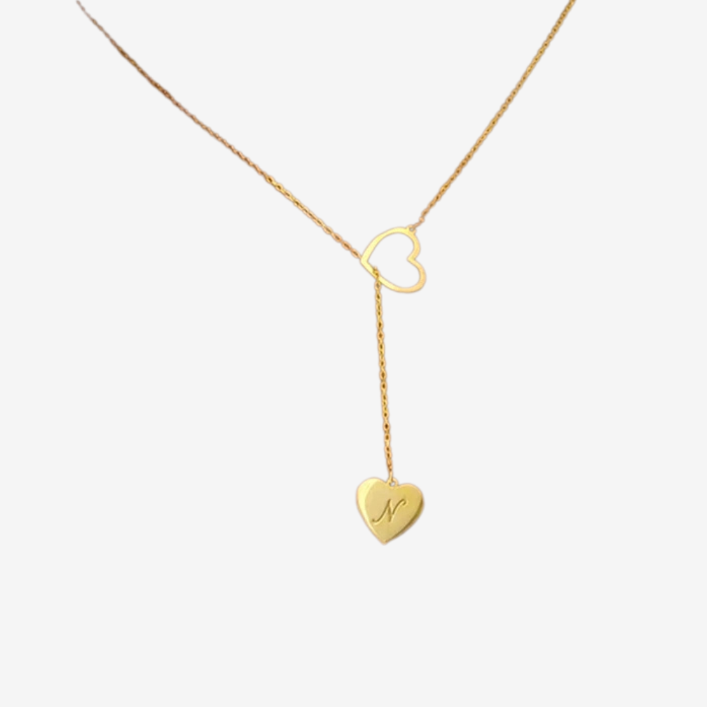 Collier initial en or, gros plan sur le cœur ajouré et le pendentif gravé