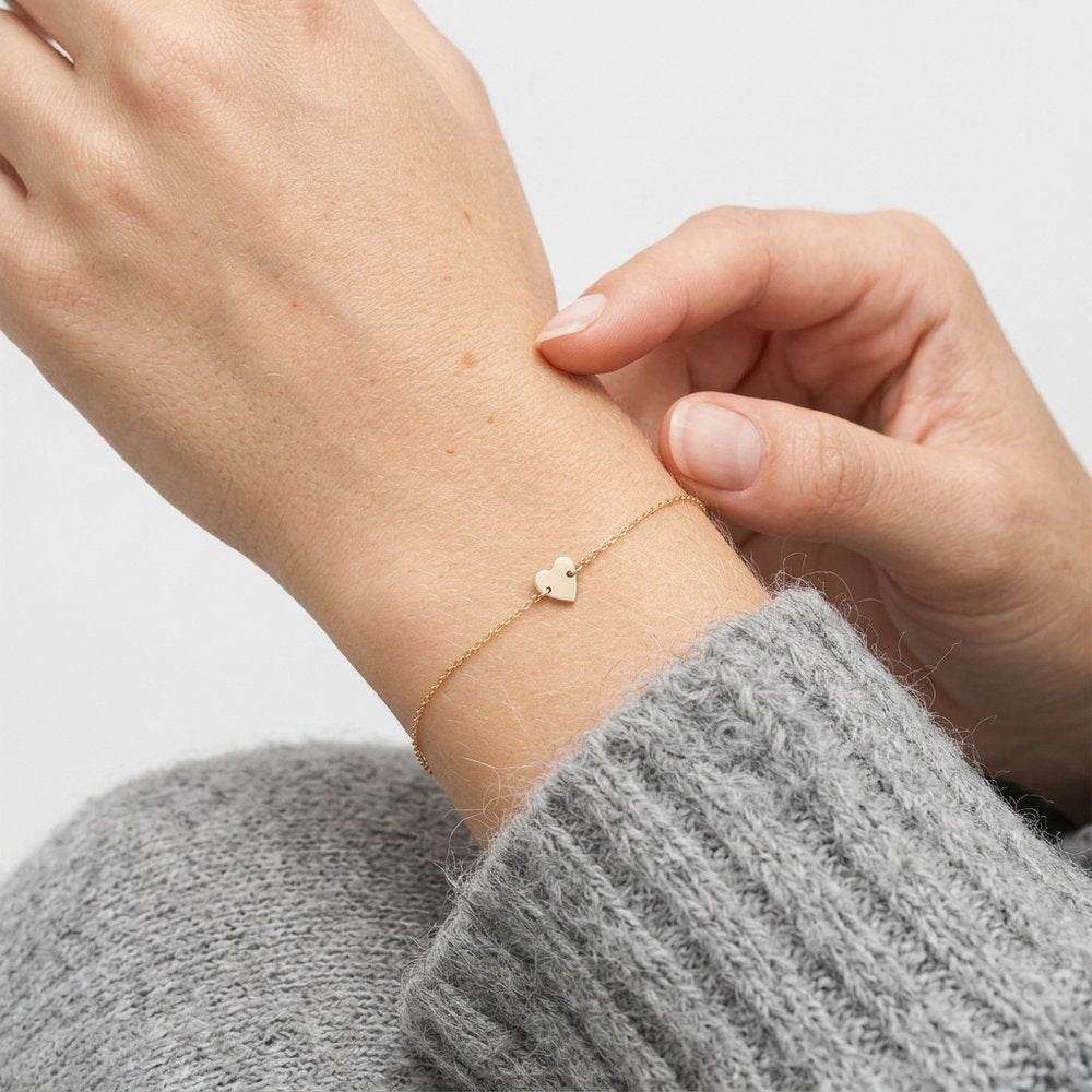 Bracelet avec un cœur discret, geste de main au poignet