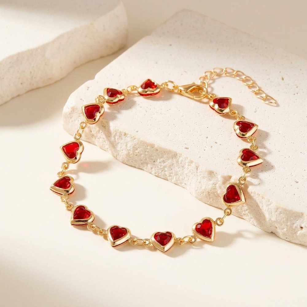 Bracelet chaîne de cœur, posé sur un support minéral ivoire