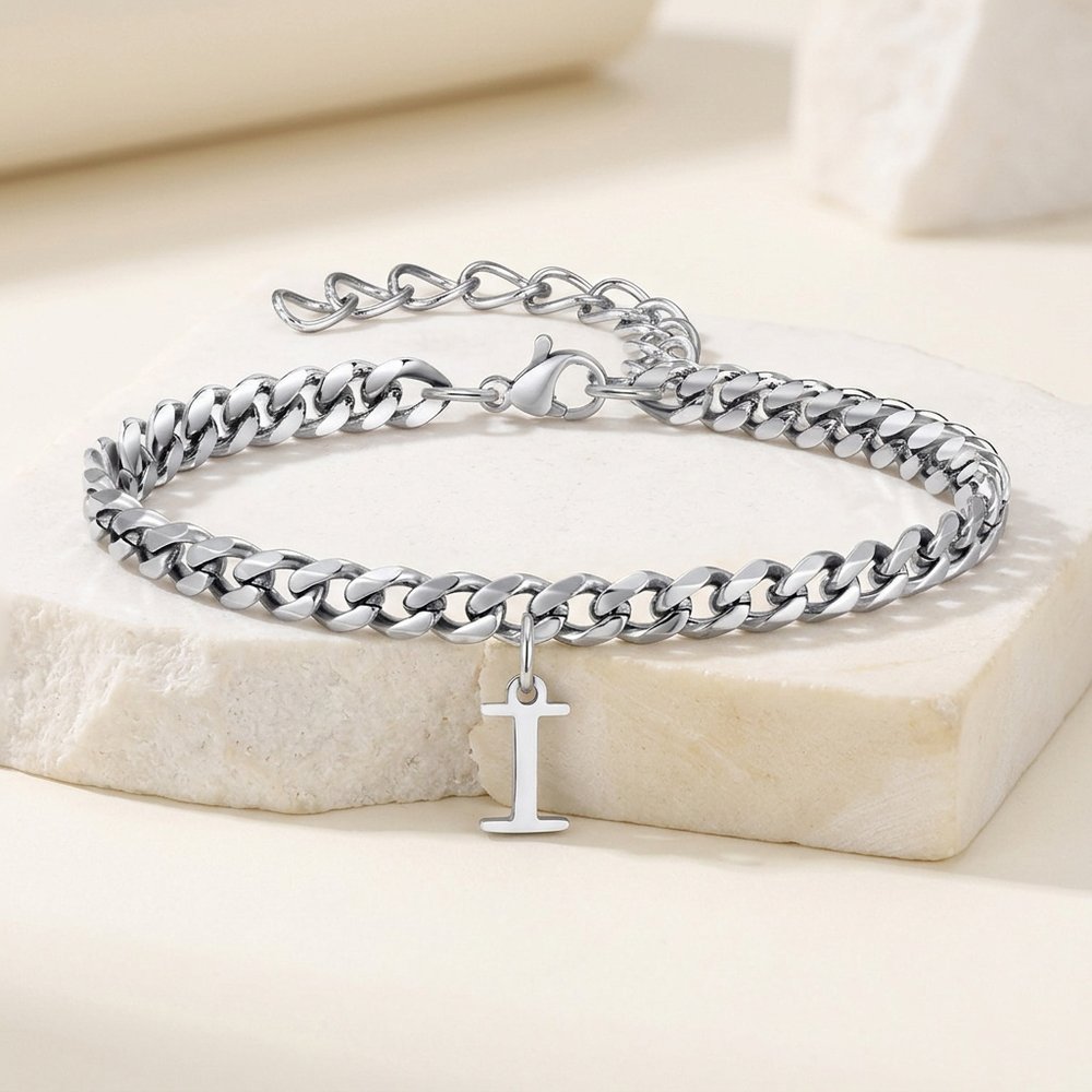 Bracelet chaîne homme posé sur une pierre minérale ivoire