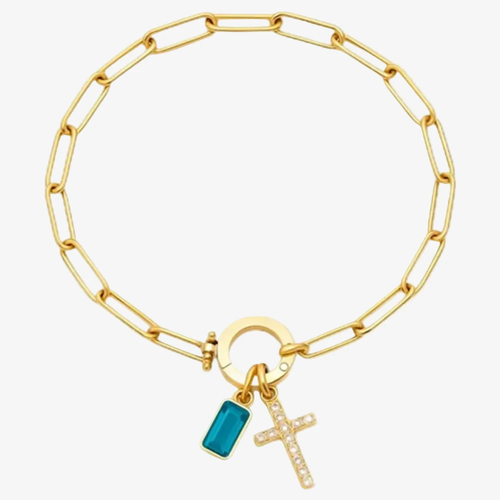 Bracelet charms avec une croix et une pierre de naissance décembre sur un fond neutre