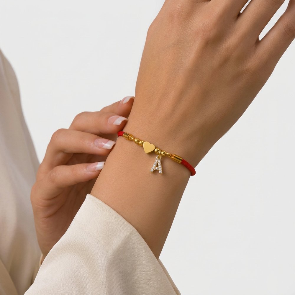 Bracelet cœur en corde rouge, geste de main au poignet
