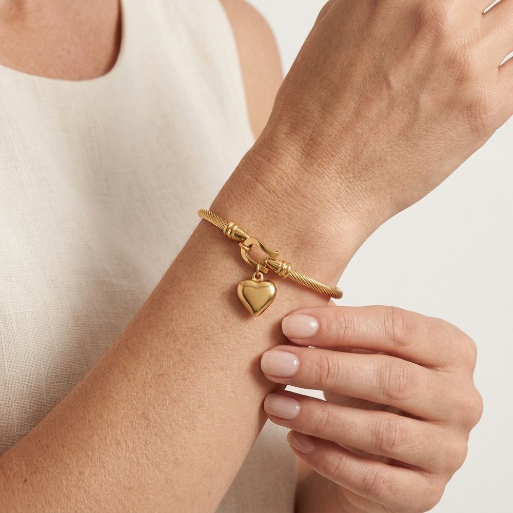 Main de femme portant le bracelet jonc femme à cœur doré