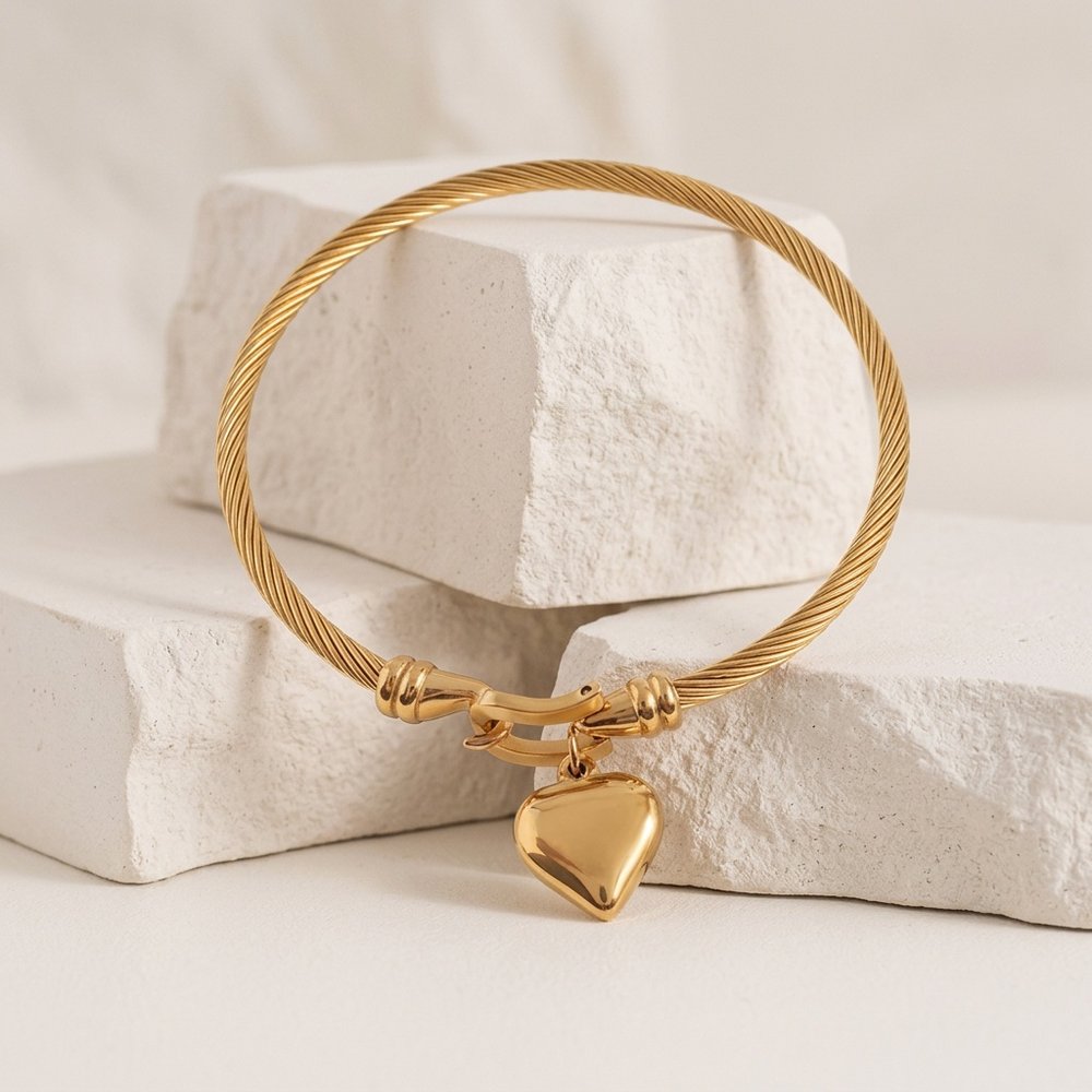 Bracelet coeur posé sur une pierre minérale ivoire