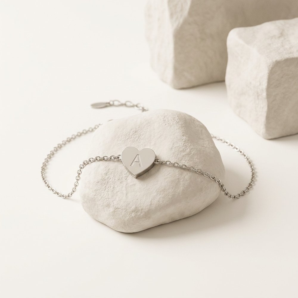 Bracelet cœur initial, posé sur un support minéral ivoire