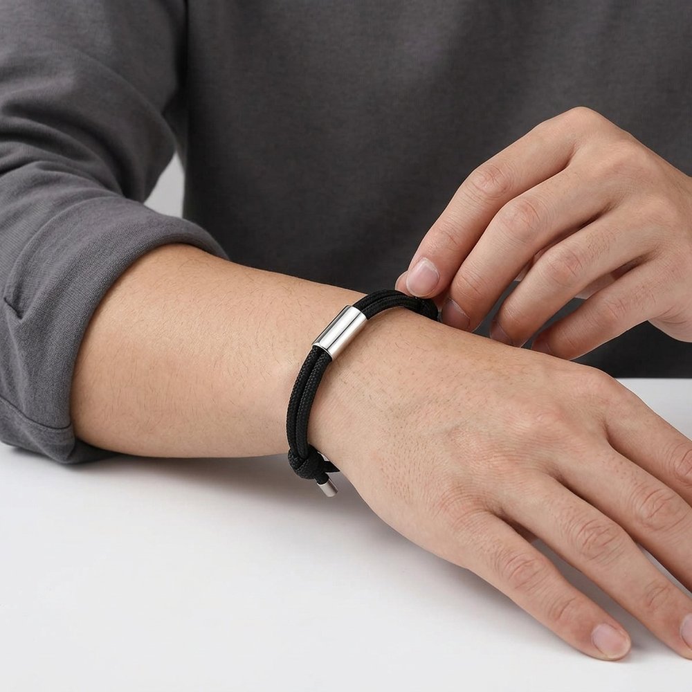 Main d'homme portant le bracelet homme corde à tube gravé