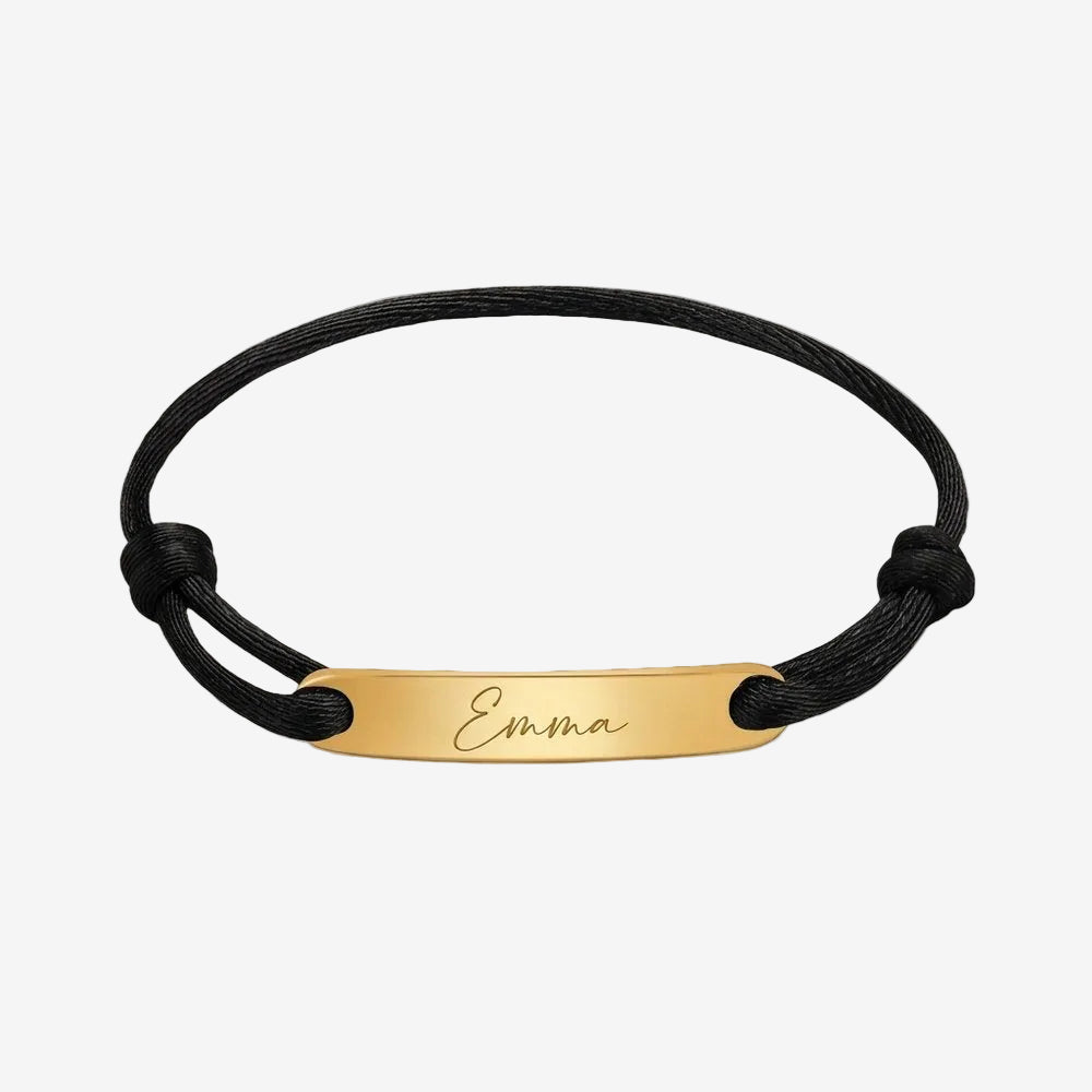 Bracelet prénom à cordon noir et plaque dorée gravée, vue produit sur fond neutre