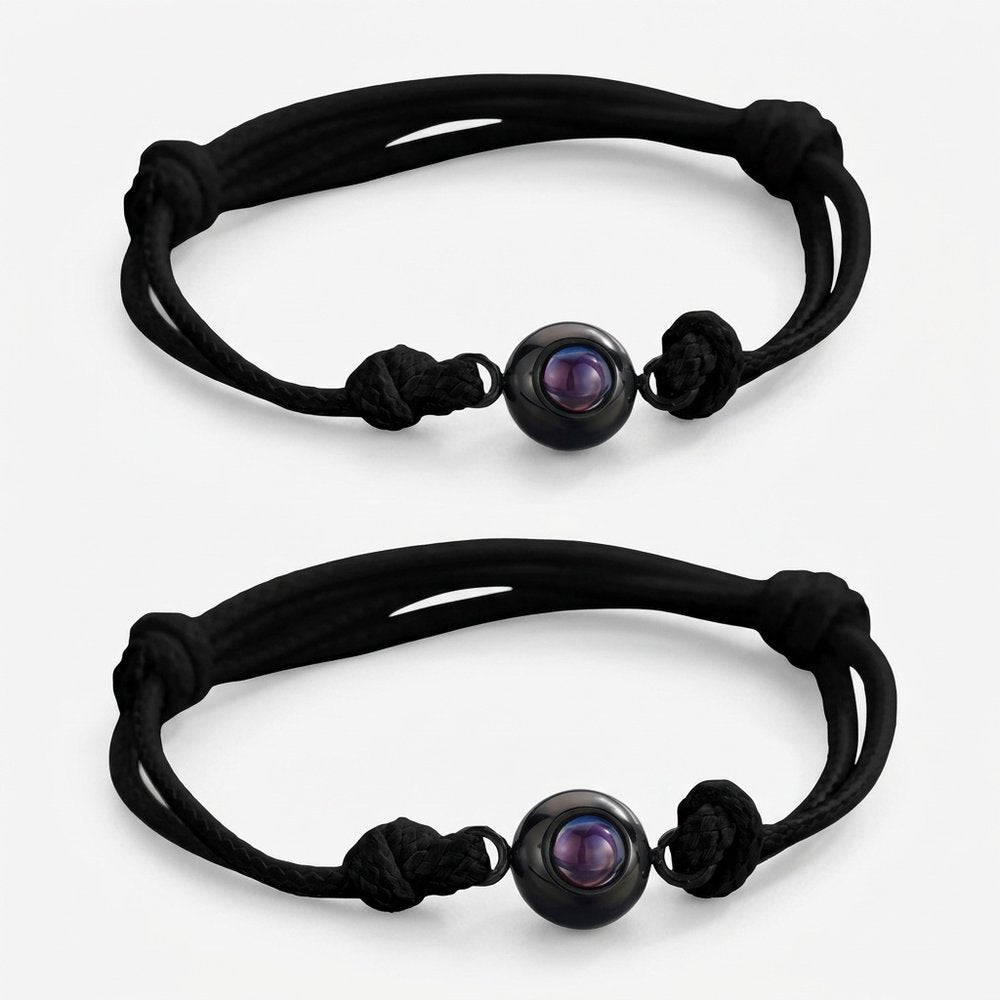 Bracelet couple avec photo projection : deux cordons noirs identiques à pendentif photo, vue produit sur fond neutre