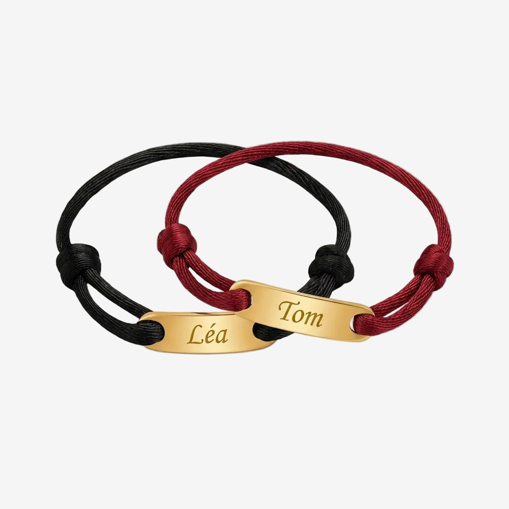 Bracelet couple corde personnalisable : deux cordons noir et bordeaux à plaque dorée gravée d'un prénom, vue produit sur fond neutre