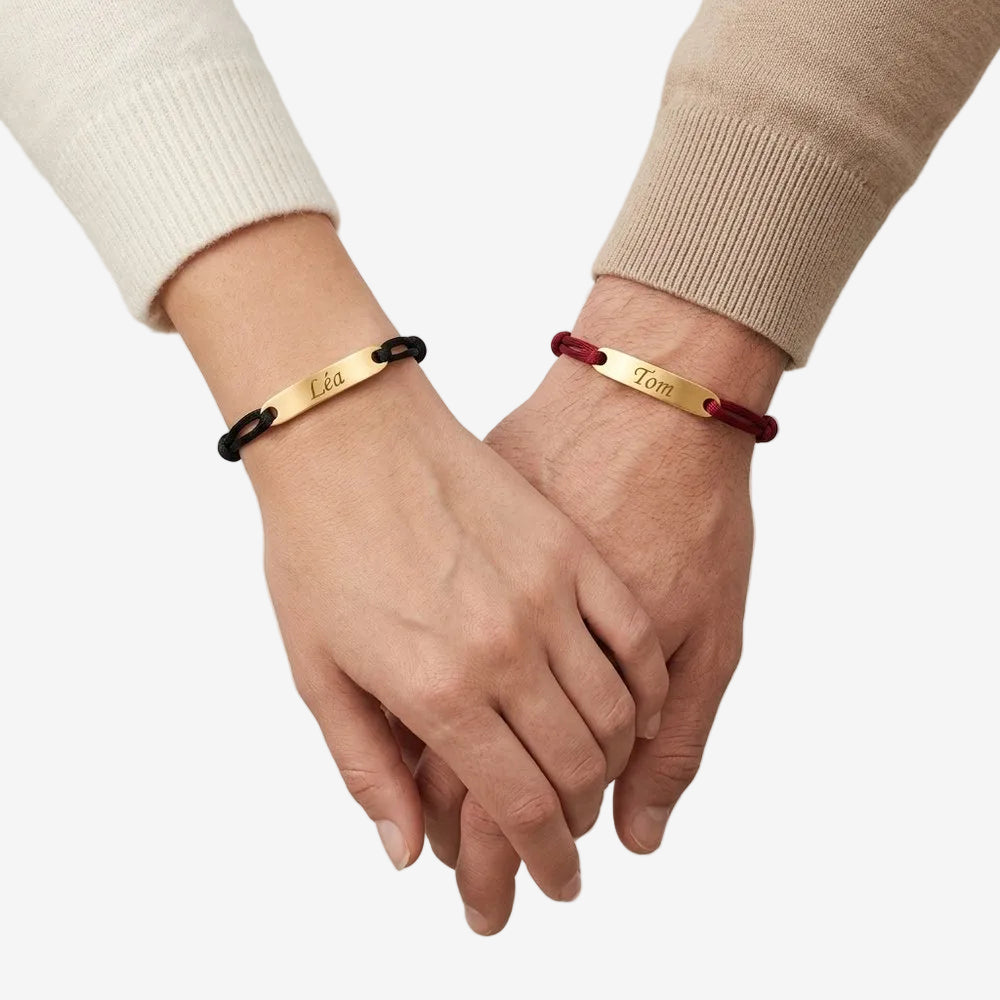 Bracelet couple corde personnalisable porté par un couple main dans la main, une plaque gravée à chaque poignet