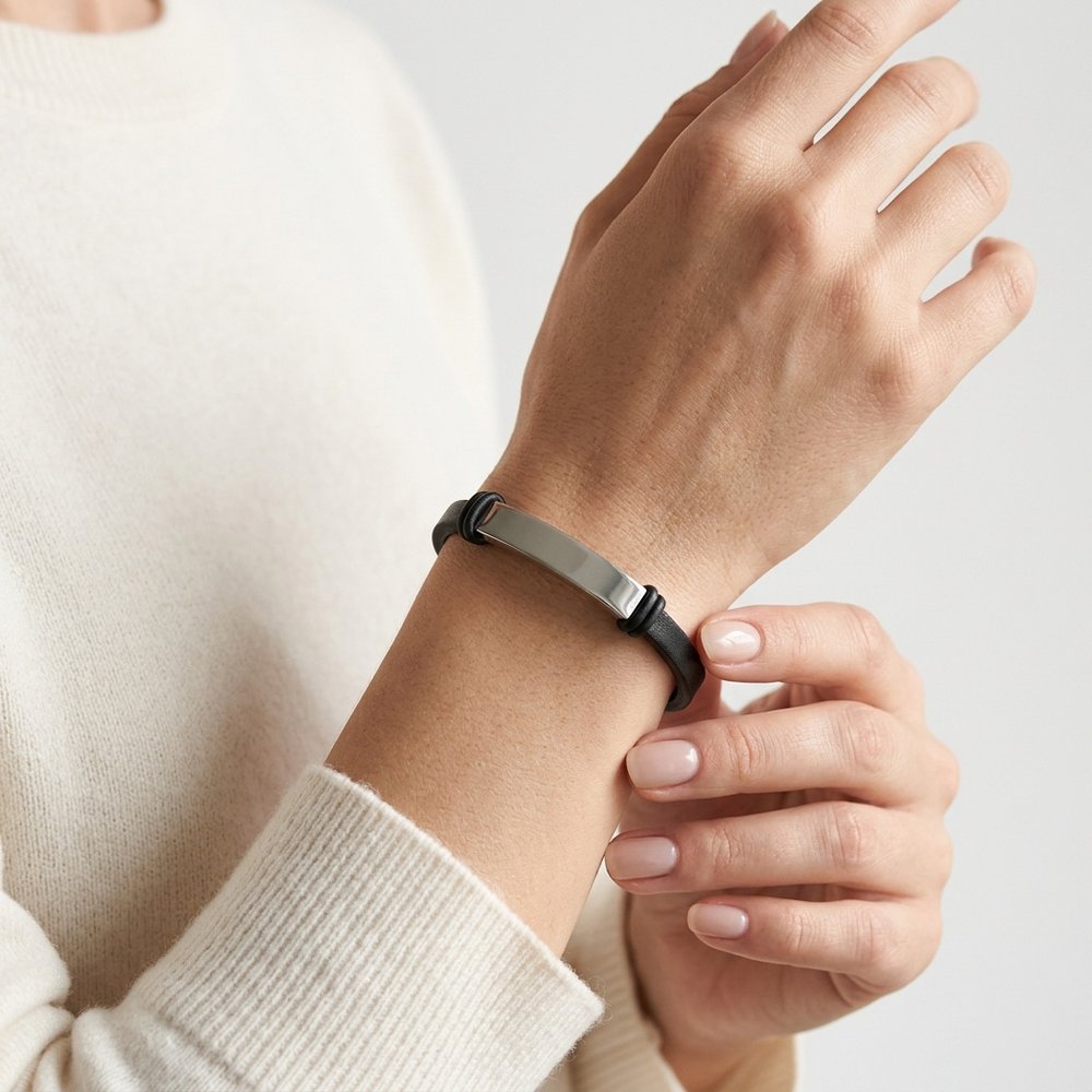 Main de femme portant le bracelet cuir fin et sa plaque en acier