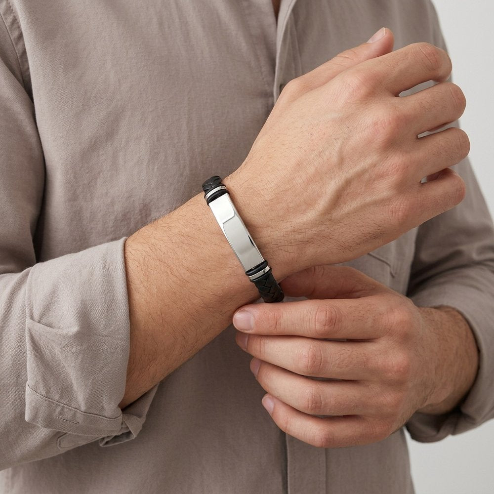 Main d'homme portant le bracelet en cuir tressé et sa plaque en acier