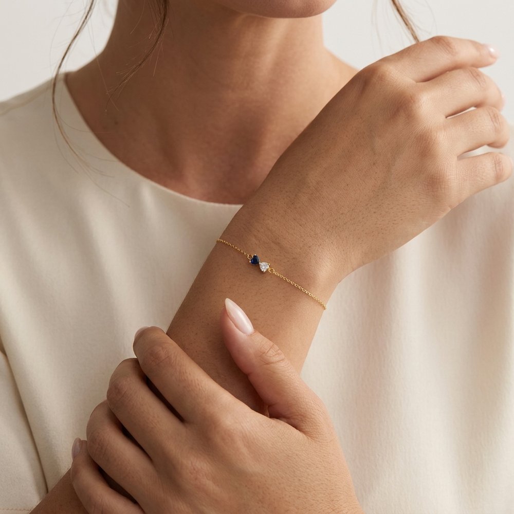 Bracelet duo de cœur, geste de main effleurant les pierres