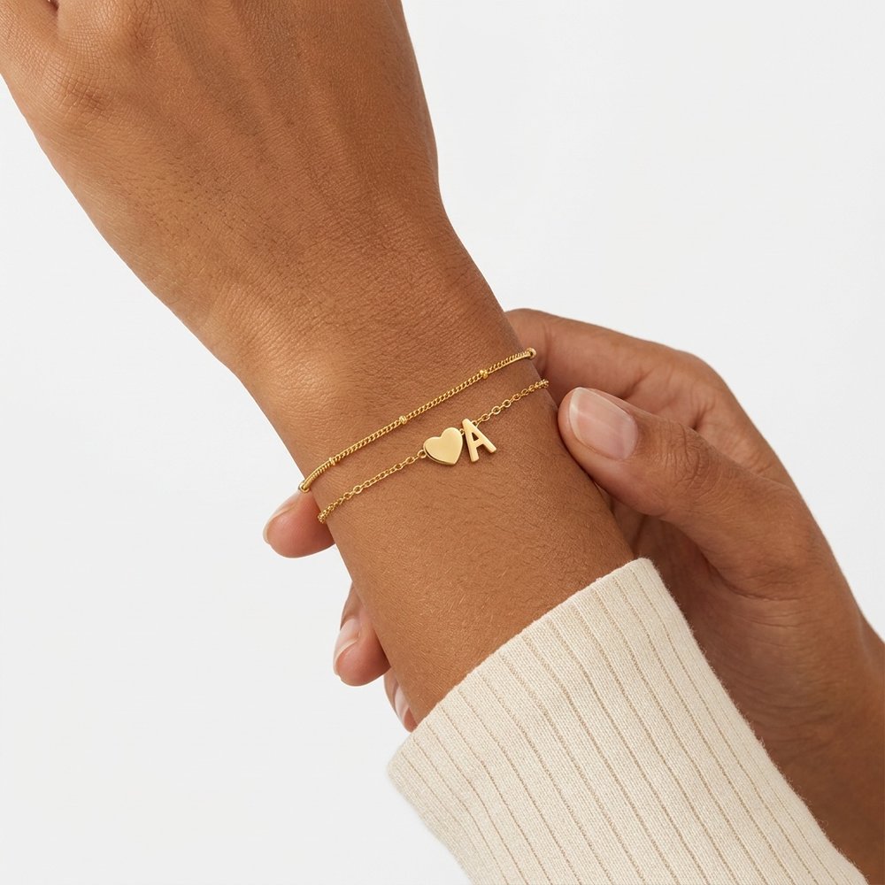 Bracelet femme cœur avec une lettre, geste de main au poignet