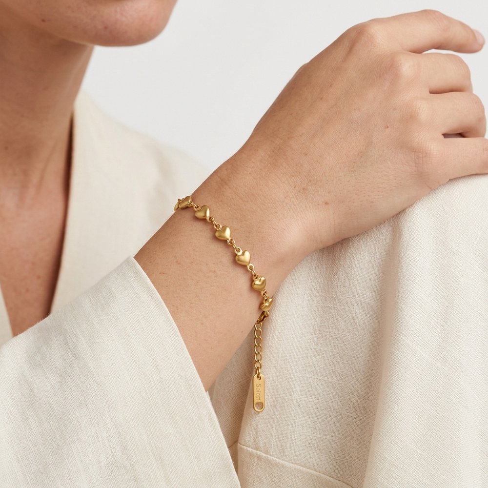 Bracelet femme cœur doré, porté au poignet