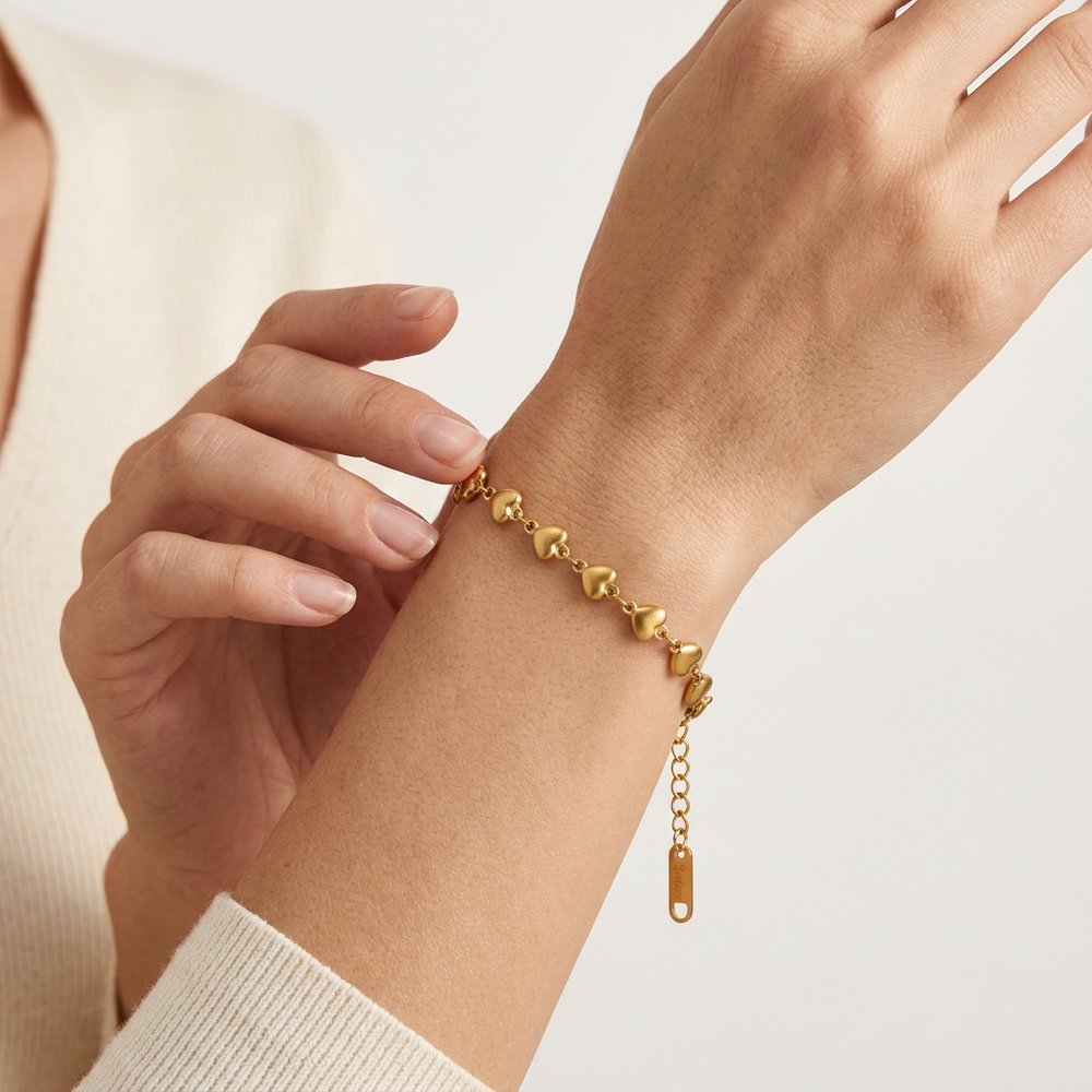 Bracelet femme cœur doré, geste de main au poignet