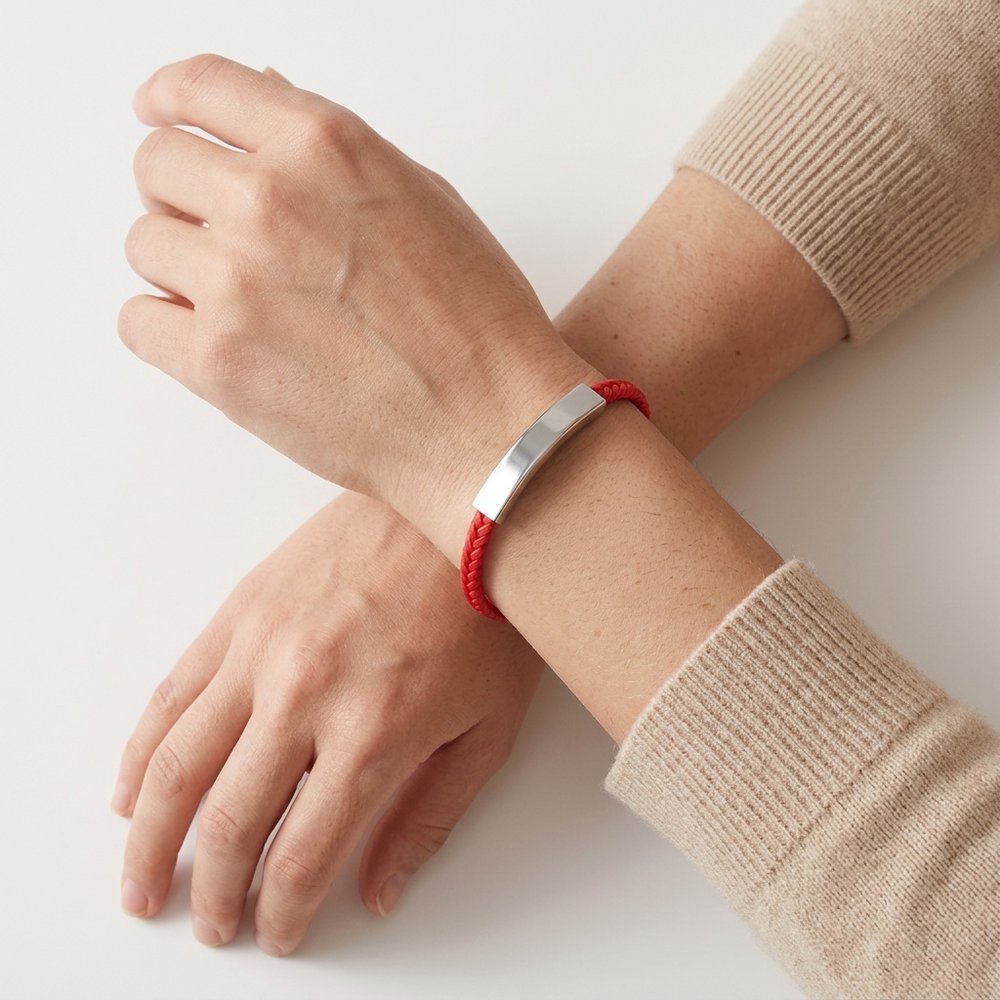 Bracelet femme gravé à cordon rouge porté au poignet d'une femme