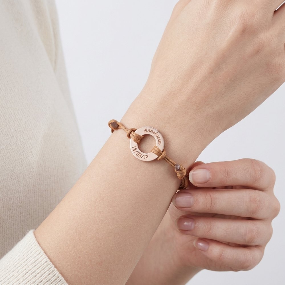 Bracelet femme personnalisé, geste de main effleurant l'anneau gravé au poignet