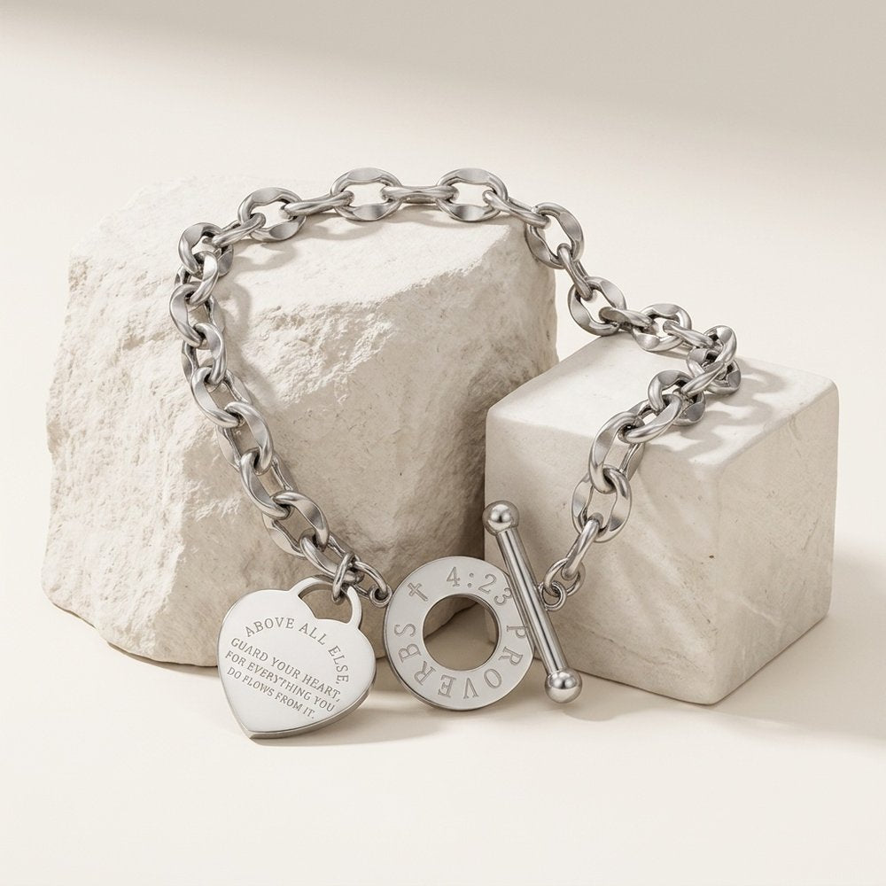 Bracelet grain de café cœur, posé sur un support minéral ivoire