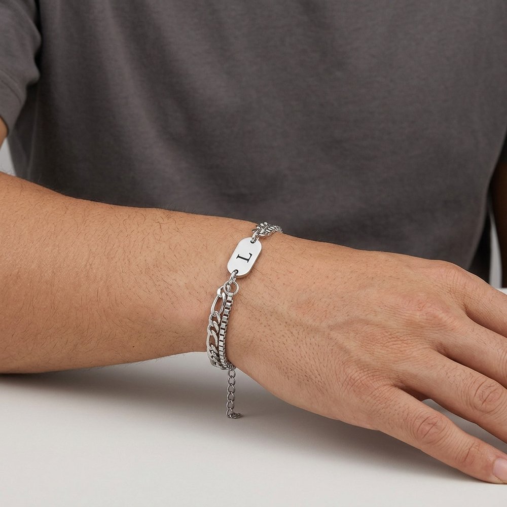 Bracelet initiale double chaîne porté au poignet d'un homme