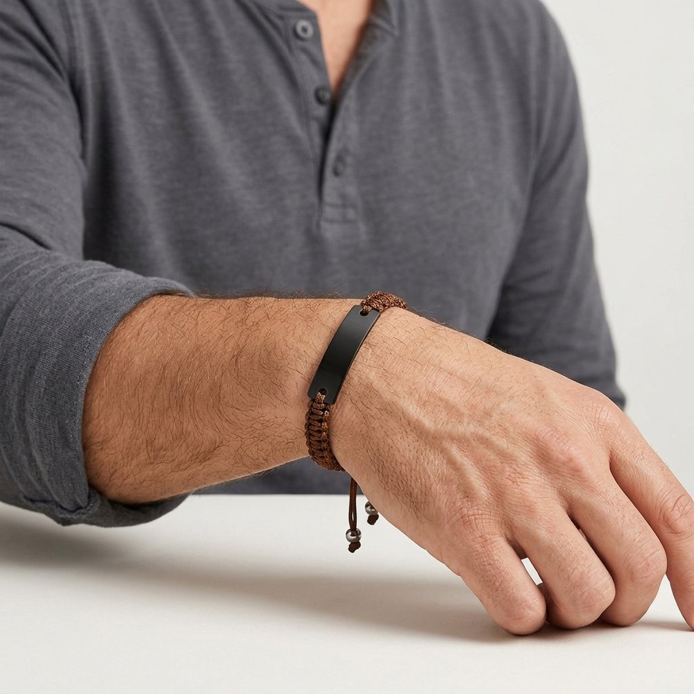 Main d'homme portant le bracelet homme macramé à plaque gravée