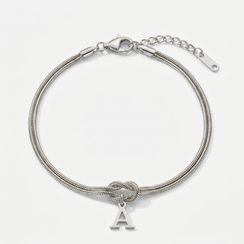 Bracelet noeud initial argenté en acier inoxydable, chaîne serpent et lettre A, vue produit sur fond neutre