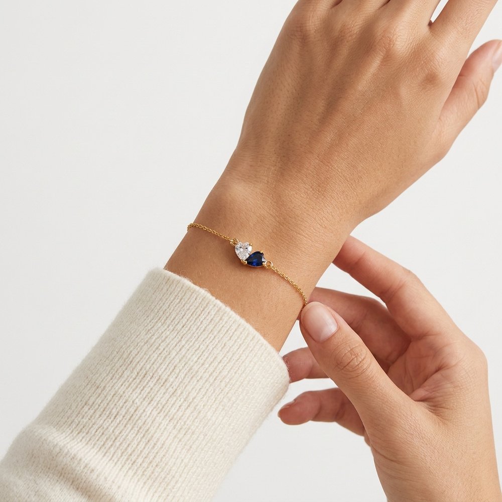 Bracelet double cœur, geste de main effleurant les pierres