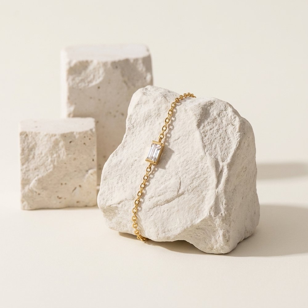 Bracelet pierre de naissance minimaliste posé sur un support minéral ivoire