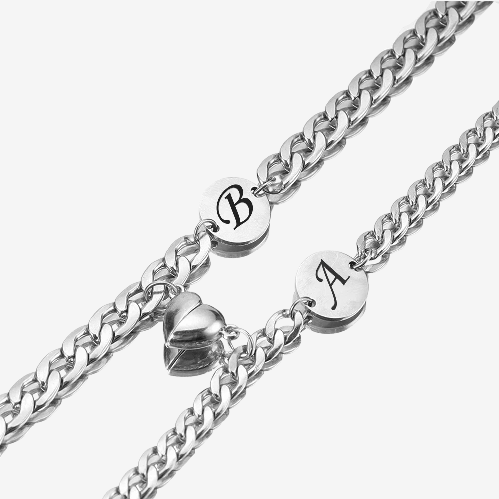 Bracelet connecté couple, gros plan sur l'aimant cœur et les initiales gravées