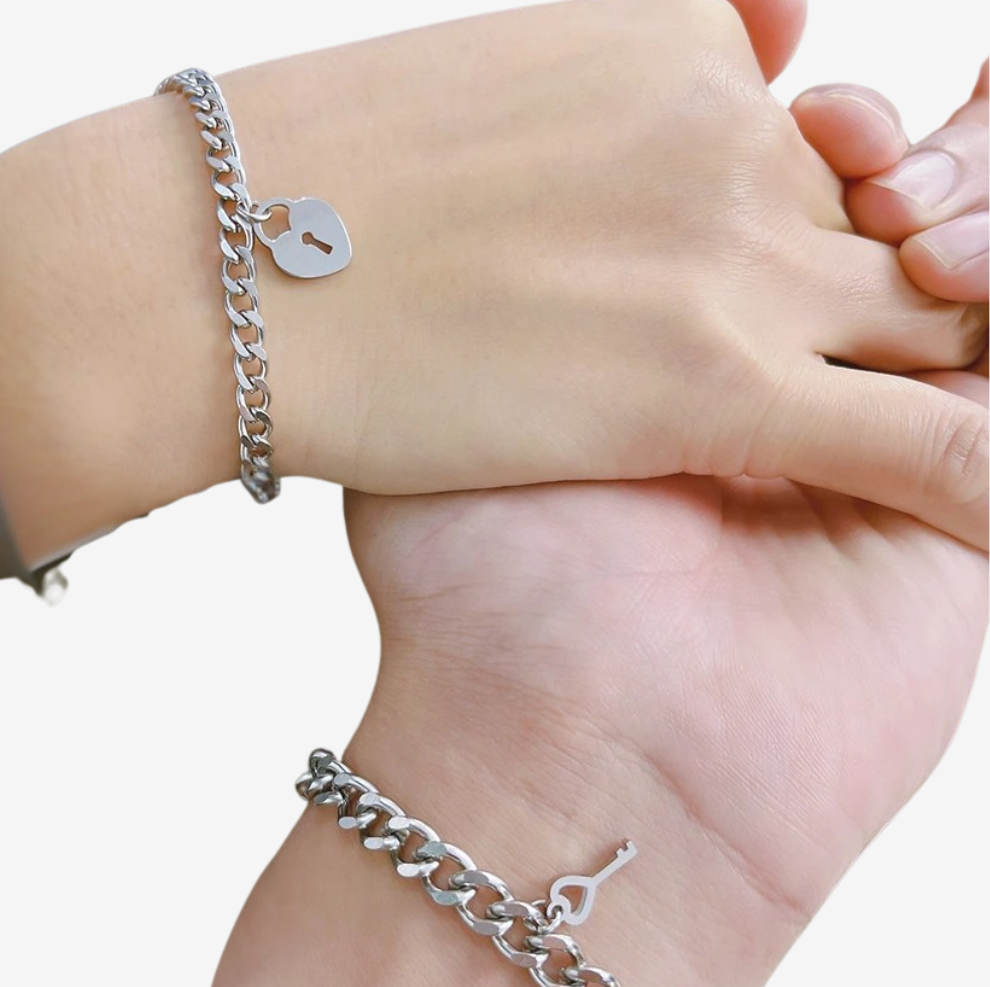 Bracelet pour amoureux porté par deux poignets, cadenas cœur et clé en acier argenté
