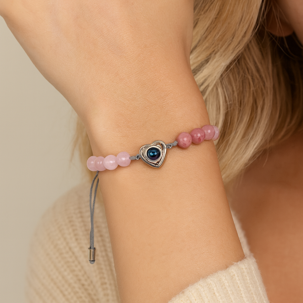 Bracelet photo loupe porté au poignet, perles roses et cœur de projection