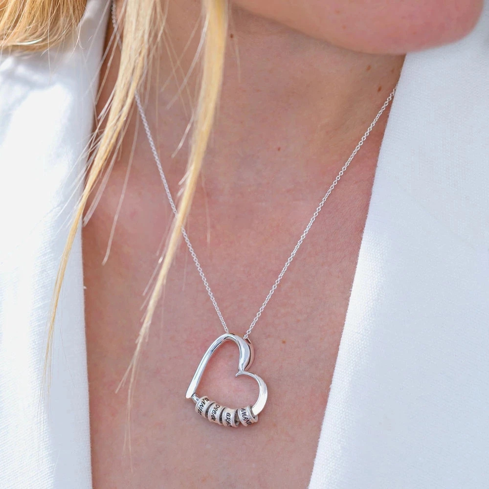 Collier cœur porté au cou, pendentif argenté et anneaux gravés