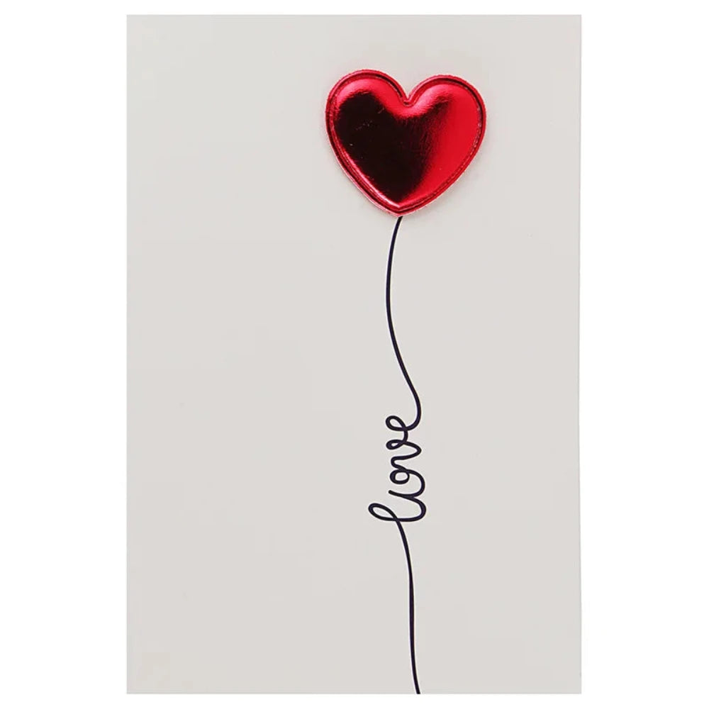 Une carte romantique avec un coeur en relief il est écris LOVE sur la carte