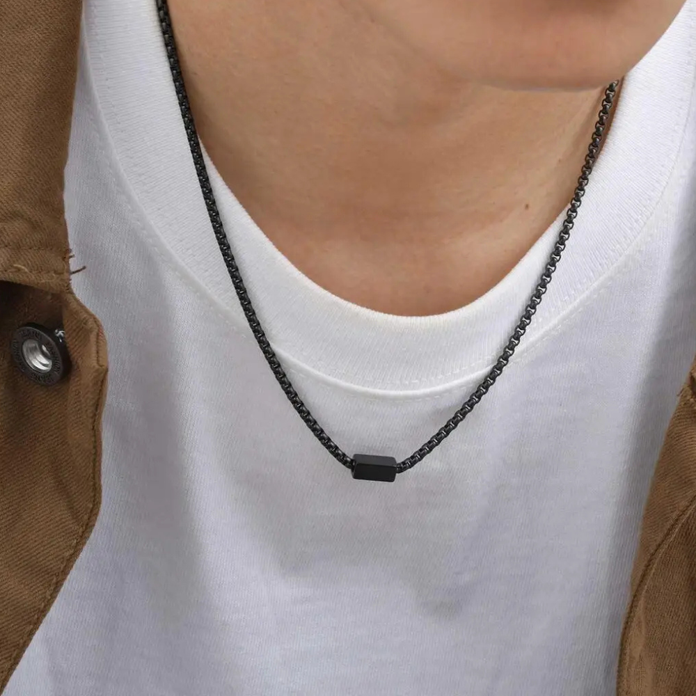 Collier chaîne homme noir porté au cou, plaque rectangulaire minimaliste
