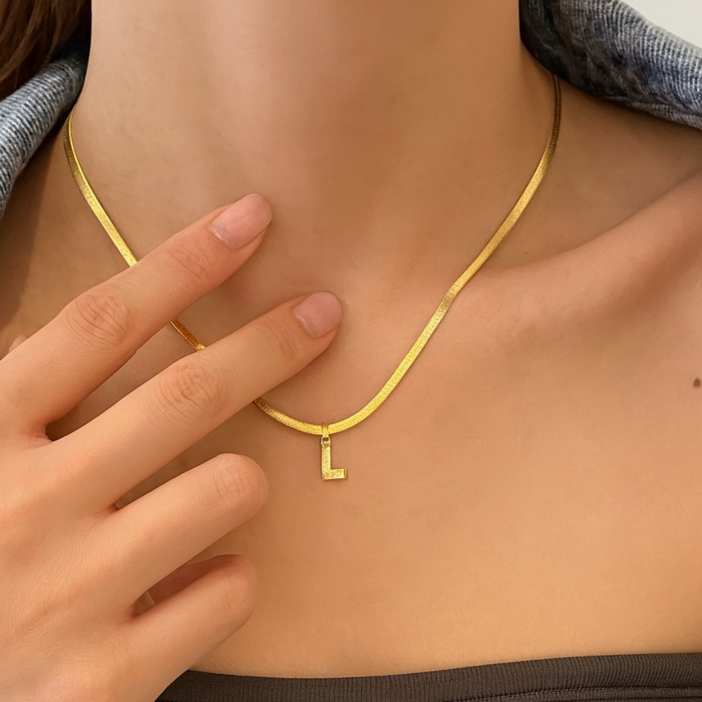 Collier lettre porté au cou, chaîne serpent dorée et pendentif initiale