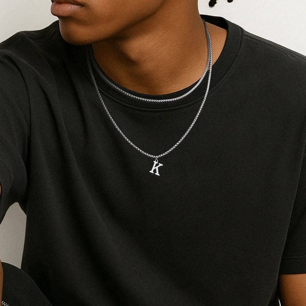 Collier homme argenté porté par un homme, chaîne fine et pendentif initiale