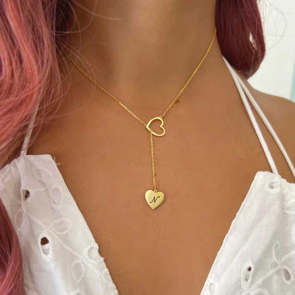Collier initial porté au cou, chaîne dorée avec cœur ajouré et pendentif gravé
