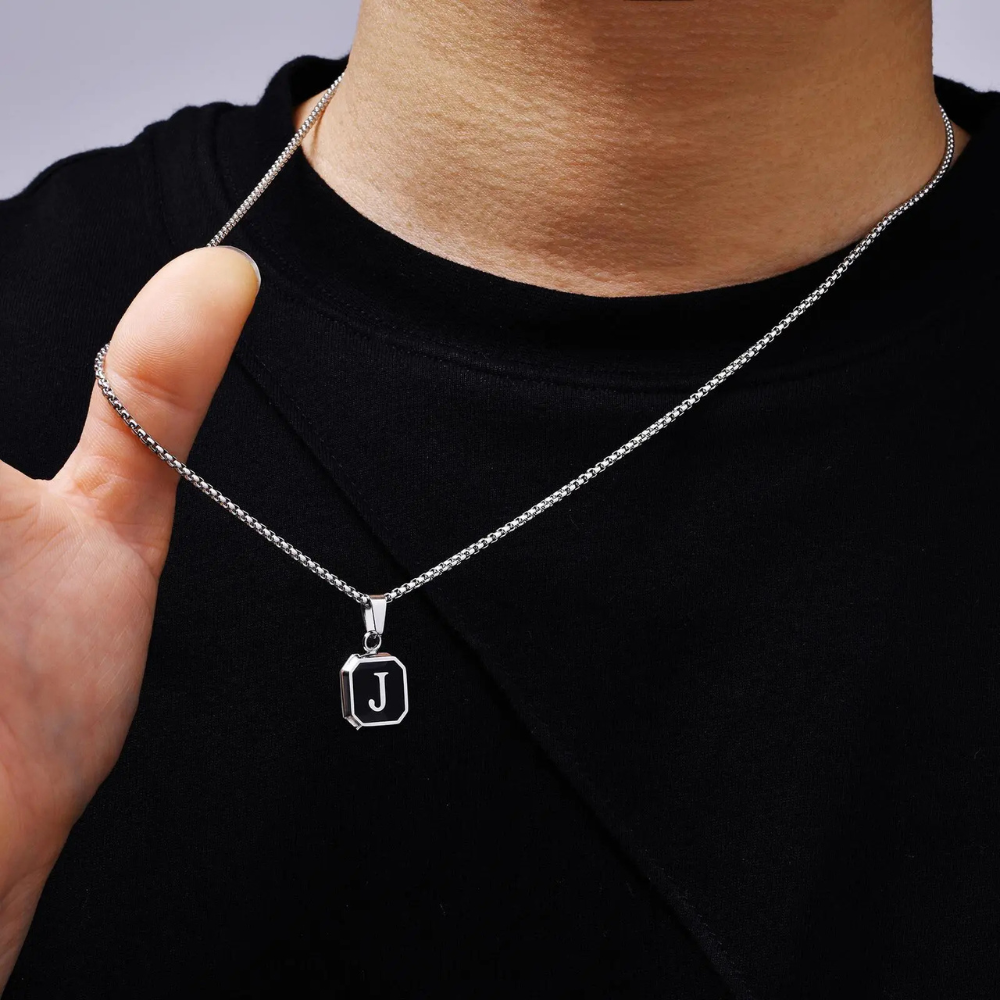 Collier homme pendentif porté par un homme, pendentif carré noir gravé