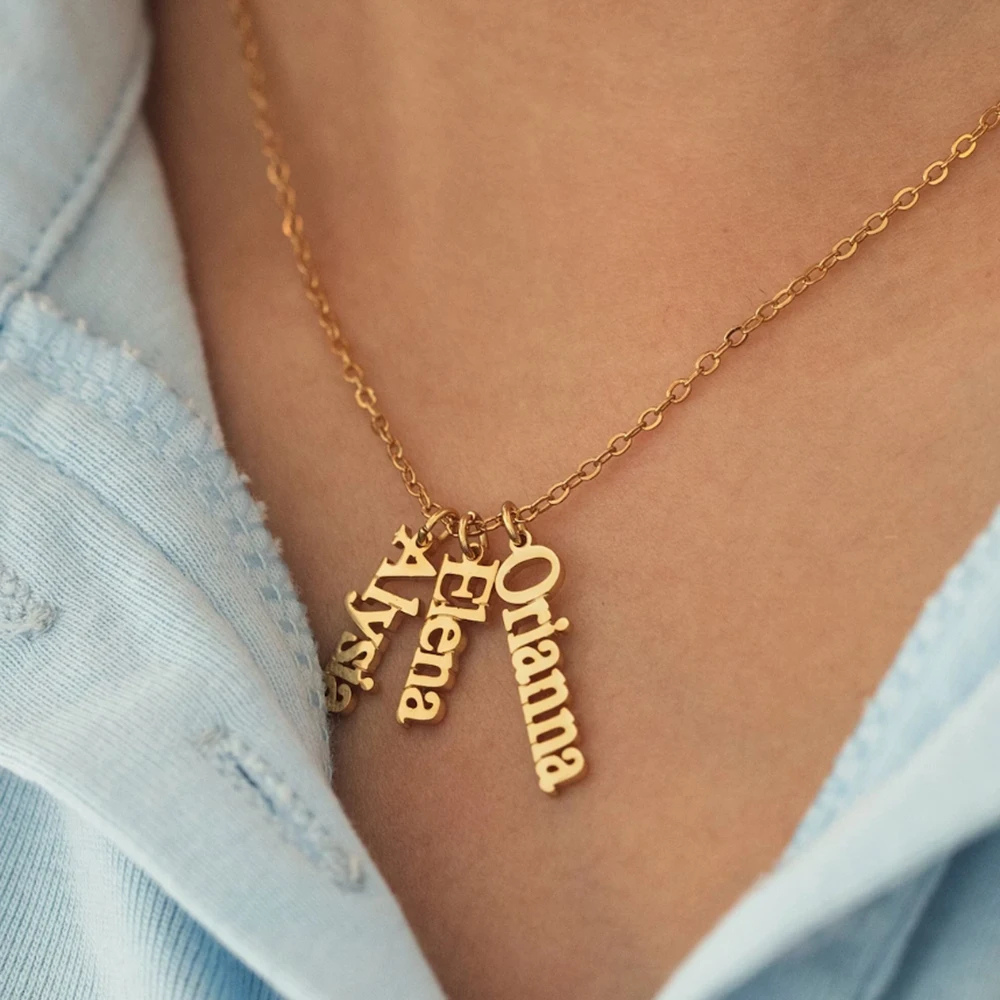 Collier prénoms personnalisés porté au cou, chaîne dorée et pendentifs verticaux