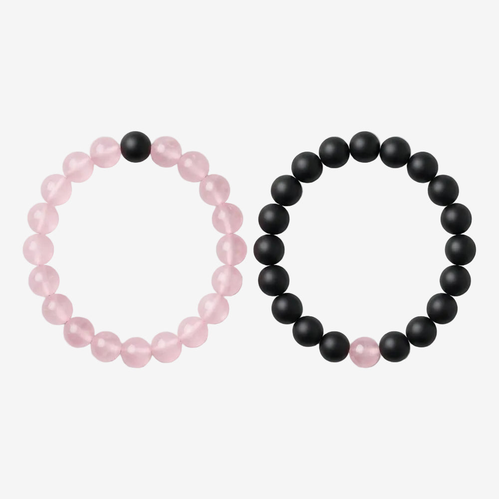 Duo de bracelet couple en pierre : un bracelet de perles roses et un bracelet de perles noires, chacun avec une perle de l'autre couleur