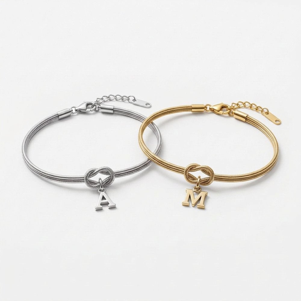 Duo de bracelet noeud un argent un or : bracelet argenté initiale A et bracelet doré initiale M, sur fond neutre