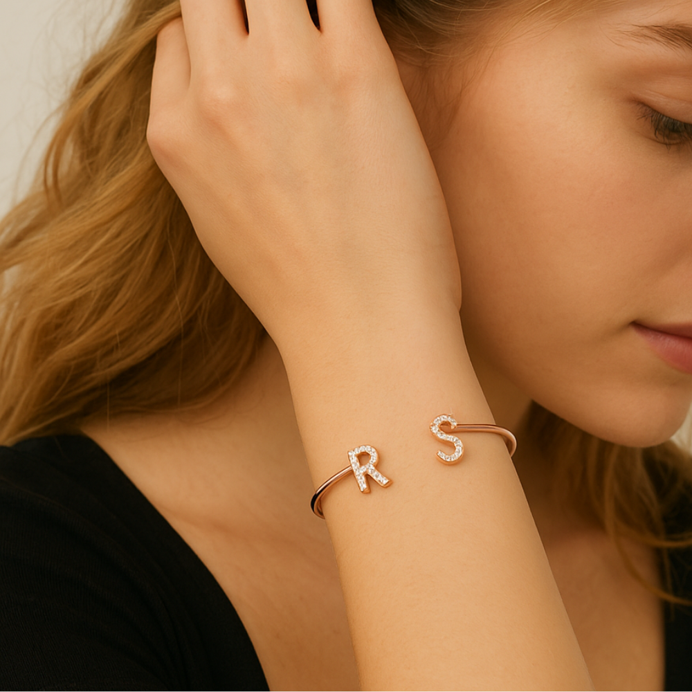 Bracelet jonc femme porté au poignet, initiales serties de zircon en or rose